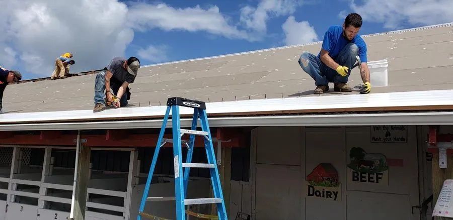 A group of men are working on the roof of a building.