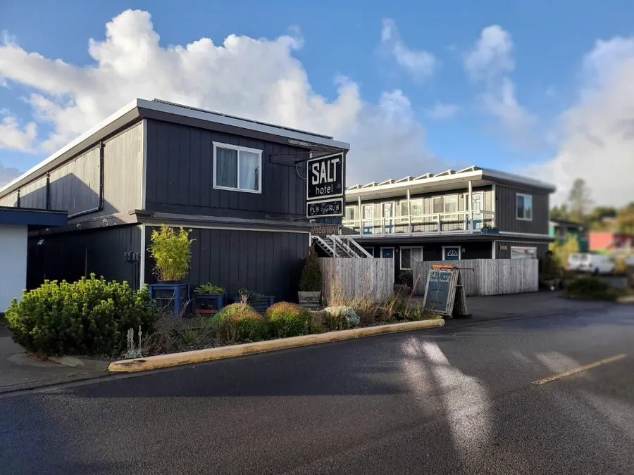 A large building with a sign that says `` salt '' is sitting next to a smaller building.