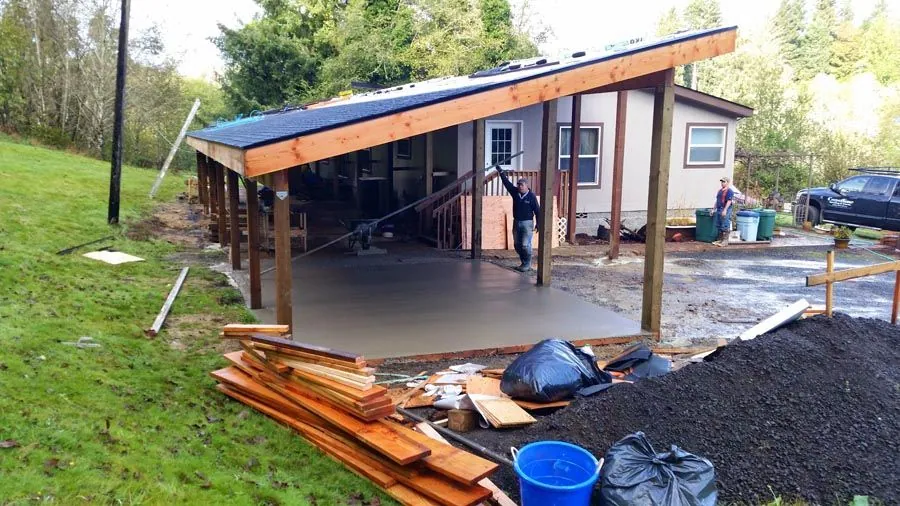 A man is standing in front of a garage under construction.