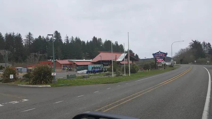 A car is driving down a road with a restaurant in the background.
