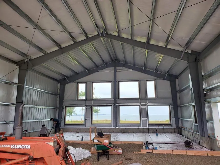 A large metal building with a lot of windows is being built.
